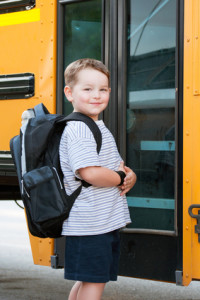 happy boy walking into school bus