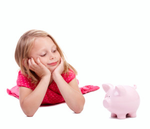 Small baby looking at piggy bank